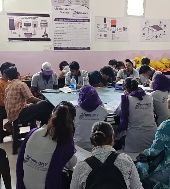 Trainees writing during a session in Kichha